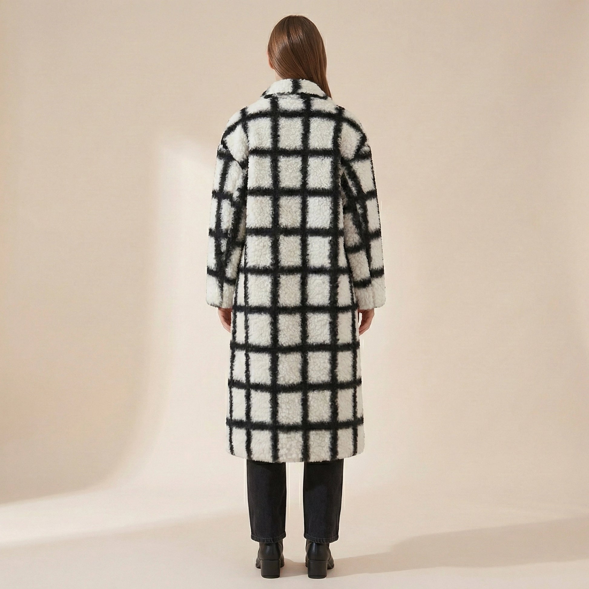 Person wearing a checkered coat on a beige background