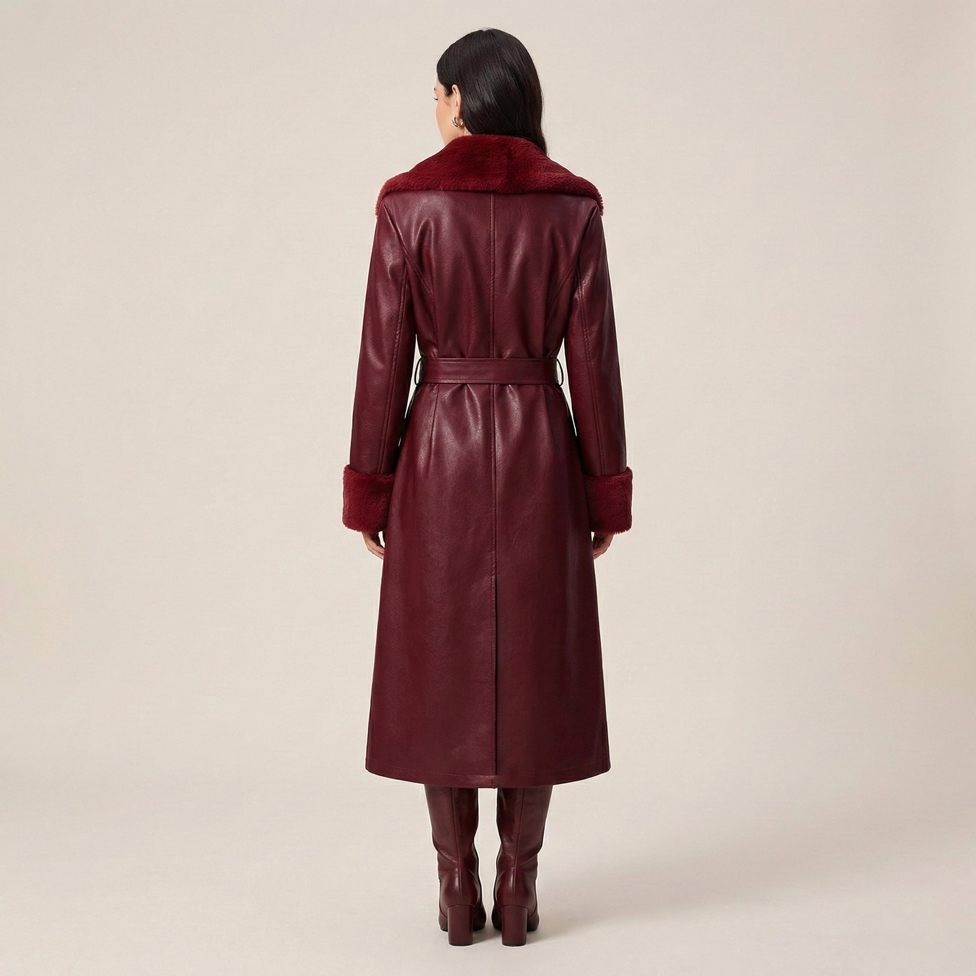 Maroon leather coat with fur collar worn by a person on a beige background