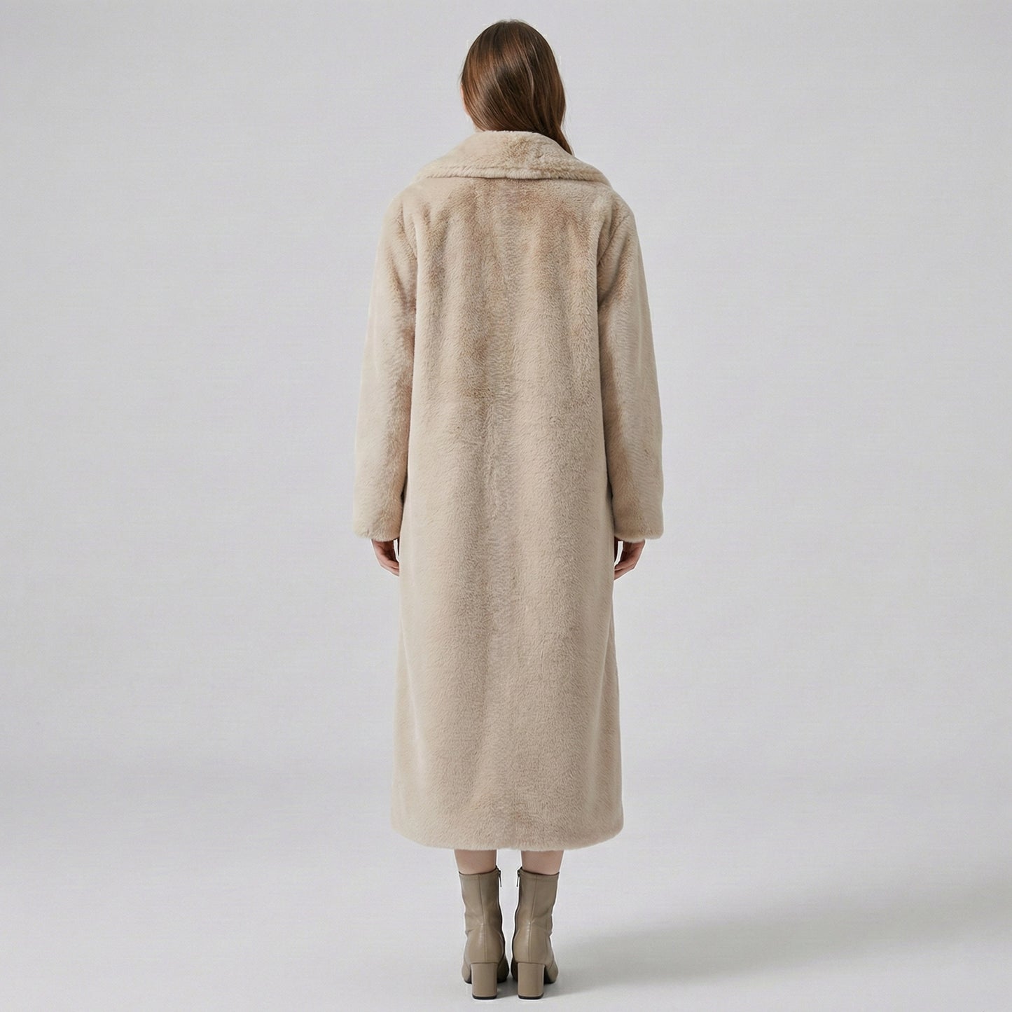 Person wearing a beige coat on a plain background