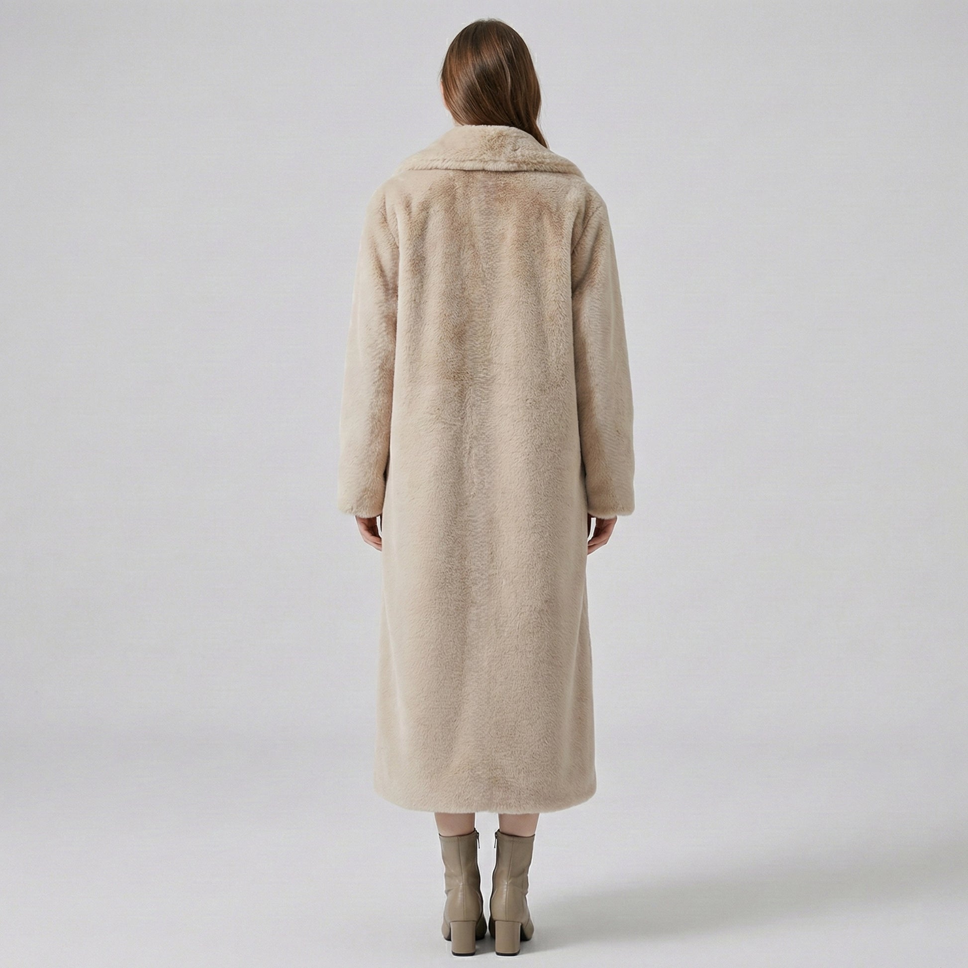 Person wearing a beige coat on a plain background