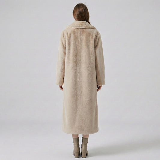 Person wearing a beige coat on a plain background