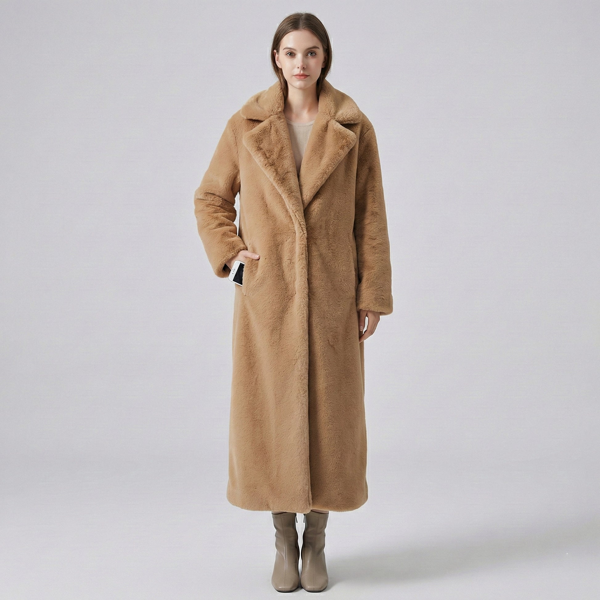 Woman wearing a long brown coat on a plain background