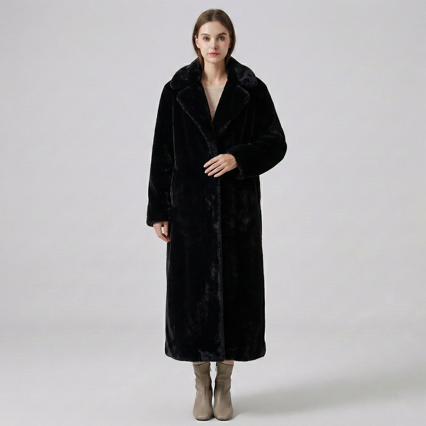 Woman wearing a long black coat on a white background